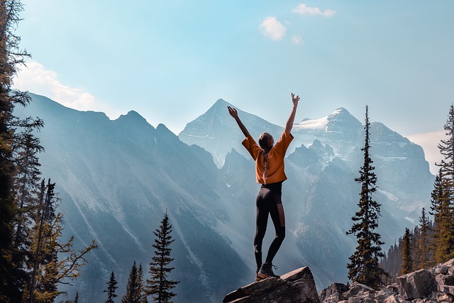 Woman on mountain, arms aloft